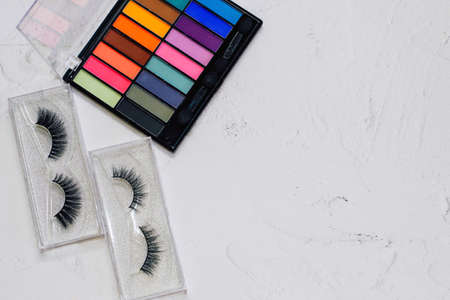 Multi-colored palette of eyeshadows with false eyelashes on a white background. Make-up for the eyelids.の写真素材