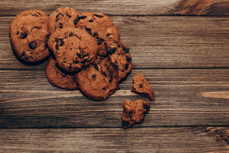 Chocolate aromatic cookies with pieces of cocoa flatley on a background of wooden boards.の写真素材