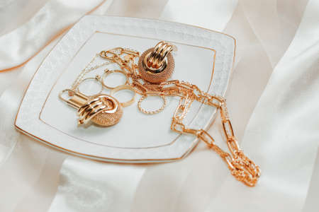 Women's jewelry earrings, trendy jewelry, rings on a plate.の写真素材