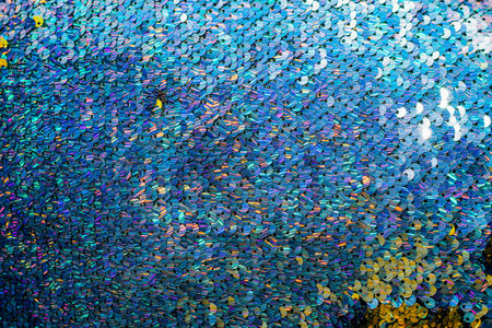 Shiny bright texture of blue sequins. Fabric for fancy dresses.