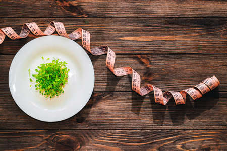 Sprouted greens of lettuce leaves microgreen in a round white mask with a centimeter.の写真素材