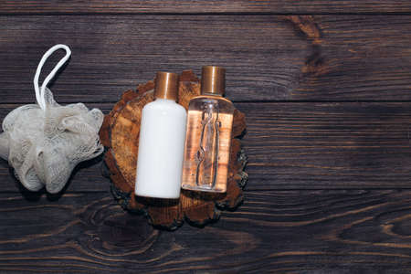 Cosmetic bottles for bathroom and washcloth on wooden background.の写真素材