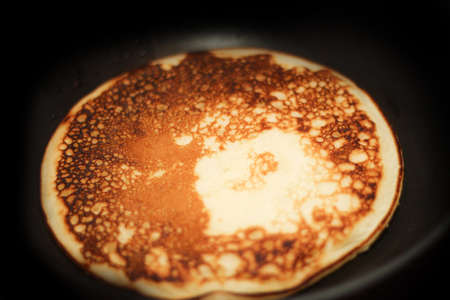 Pancake is fried in a pan. Rosy hot sweet breakfast.の写真素材