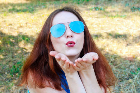 Young pretty girl with red hair listens to music in wired summer.の写真素材