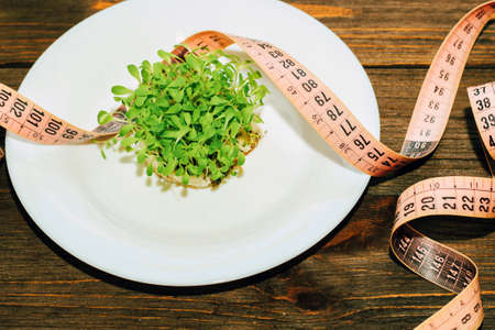 Sprouted greens of lettuce leaves microgreen in a round white mask with a centimeter.の写真素材