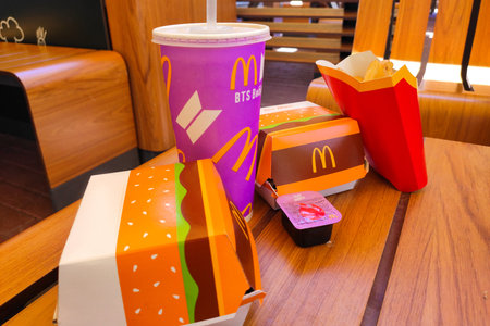 Ukraine, Cherkasy - JUNE 14, 2021: New design of menu packages at McDonald's. Cola, big mac, potatoes and sauce.のeditorial素材