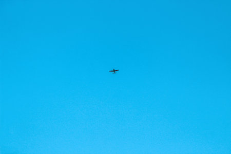 the plane is high in the sky against the background of a dove without clouds.の写真素材