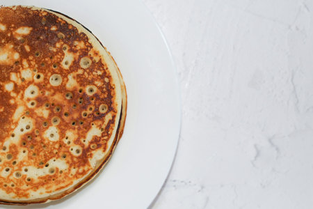 Pancakes in a snow-white plate. Rosy hot sweet breakfast.