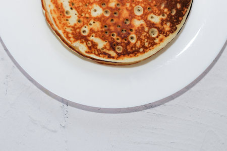 Pancakes in a snow-white plate. Rosy hot sweet breakfast.の写真素材