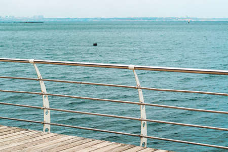 embankment from wooden boards railing on a blue sea background on the water surface.の写真素材