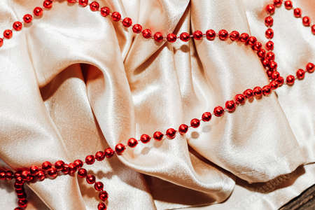 Shiny golden textured silk background in folds with beads.の写真素材