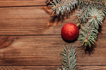Christmas background with fir sprig and red toys on wooden boards.の写真素材