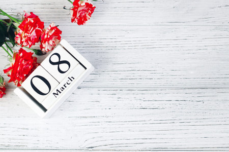 On a wooden calendar the inscription March 8 with a bouquet of roses.