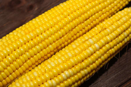 Sweet yellow corn lies on a wooden table.の写真素材