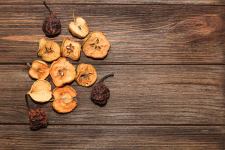 Dried apples and pear fruits on a plate on a wooden table.の写真素材