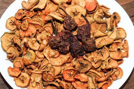 Dried apples and pear fruits on a plate on a wooden table.の写真素材
