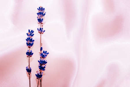 Silk fabric texture with lavender sprigs on pink background.の写真素材