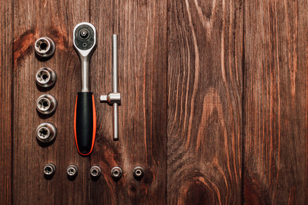 Tools wrench and nuts on wooden background.