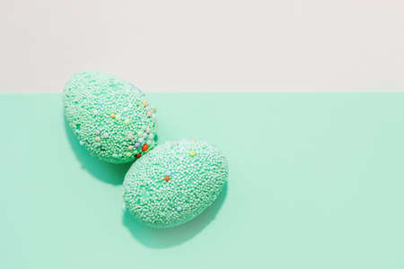 Green Easter decorative eggs on a pastel background.の写真素材