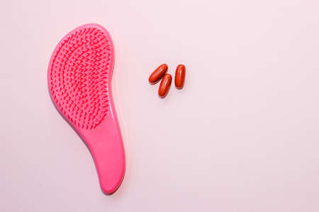 Comb plastic roses and pills vitamins on a cardboard backgroundの写真素材
