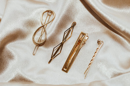 Golden hairpins on golden silk background, social media content.