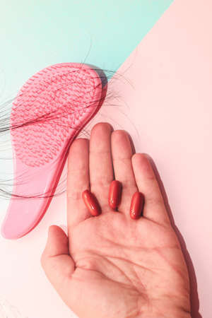Comb plastic roses and pills vitamins in hand.の写真素材