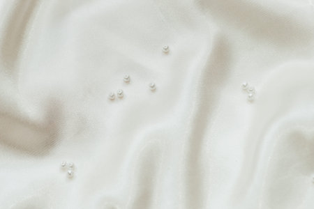 Pearl bijouterie beads on silk texture background.