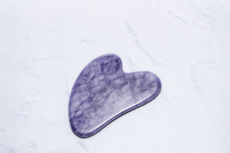 massage stone amethyst gouache scraper light background.の写真素材
