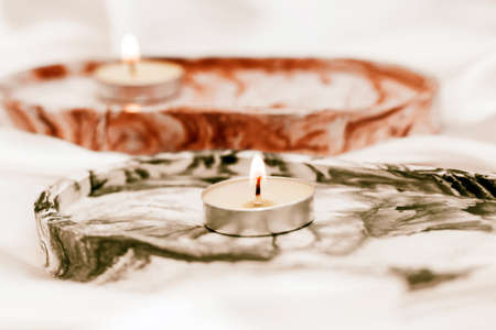 Gypsum marble decorative stand with candles on the background of silk stand.の写真素材