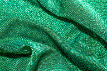 Texture of shiny sparkling lurex fabric green color.