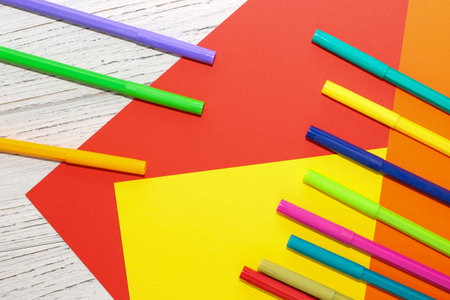 Multi-colored stationery felt-tip pens on a background of multi-colored cardboard paper.の写真素材