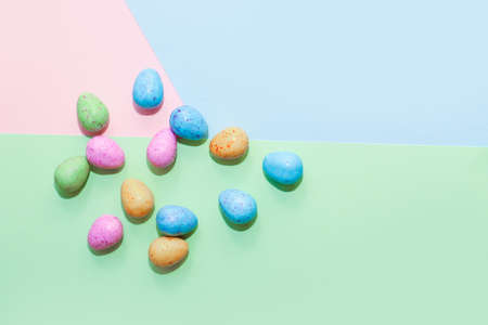 Multi-colored Easter decorative eggs on a pastel background.の写真素材