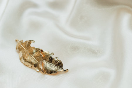 Golden hairpins on golden silk background, social media content..