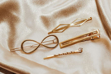 Golden hairpins on golden silk background, social media content.の写真素材
