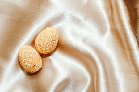 Multi-colored Easter decorative eggs on silk gold background.の写真素材