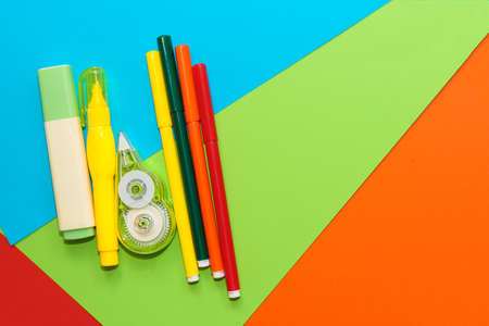 Yellow stationery corrector and markers on a background of multi-colored cardboard paper.の写真素材