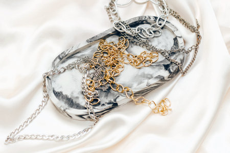 Gypsum marble decorative stand and silver and gold jewelry on the background of silk stand.