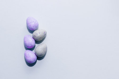 Purple lavender chocolate easter candy eggs on paper background.の写真素材