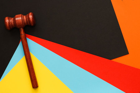 Wooden gavel of the judge on the background of different cardboard paper.