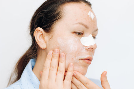 The girl is doing makeup, correcting the impending eyelid, one part of the face is not made up.の写真素材