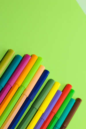 Multi-colored stationery felt-tip pens on a background of multi-colored cardboard paper.の写真素材