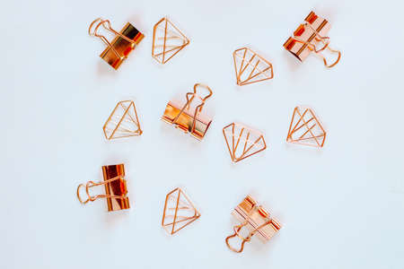 Glasses, paper clips in the form of rose gold diamonds on a white background.の写真素材