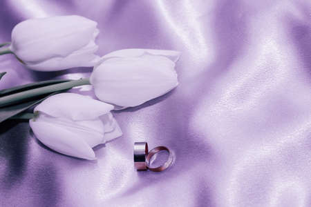 Bouquet of white tulips on a silk golden nude satin background, lavender photo processing.の写真素材