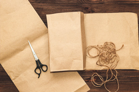 Craft paper for gift wrapping with scissors on a wooden background.の写真素材