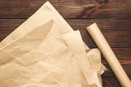 Kraft paper in a roll for packing parcels on a wooden background.の写真素材