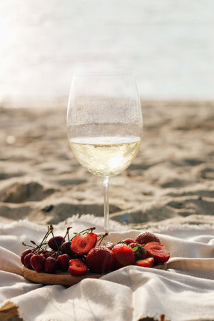 Champagne with a tray of fruits, strawberries and cherries on a picnic.の写真素材