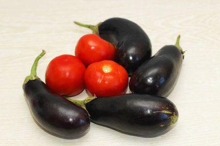Eggplant and tomatoes on the table before cooking.の写真素材