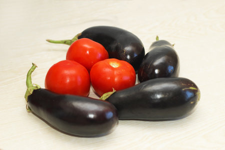 Eggplant and tomatoes on the table before cooking.の写真素材