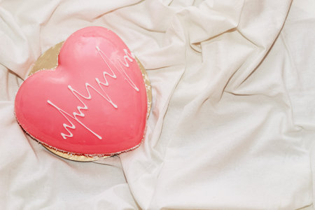 Heart shaped pink mousse cake on the table.の写真素材