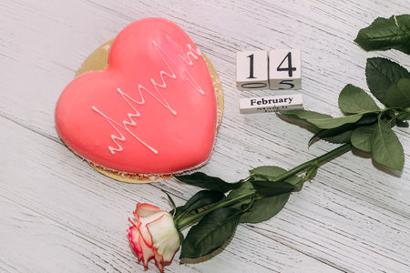 Pink tea rose with heart shaped pink mousse cake and February 14 calendar.の写真素材
